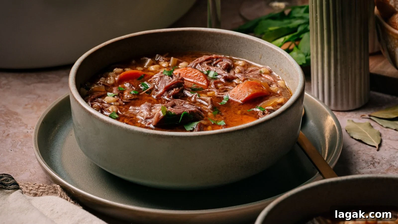 21 Slow Cooker Dinners for Stress-Free Weeknight Meals 11 Hearty slow-cooked beef and barley soup filled with tender short rib pieces in a deep bowl.