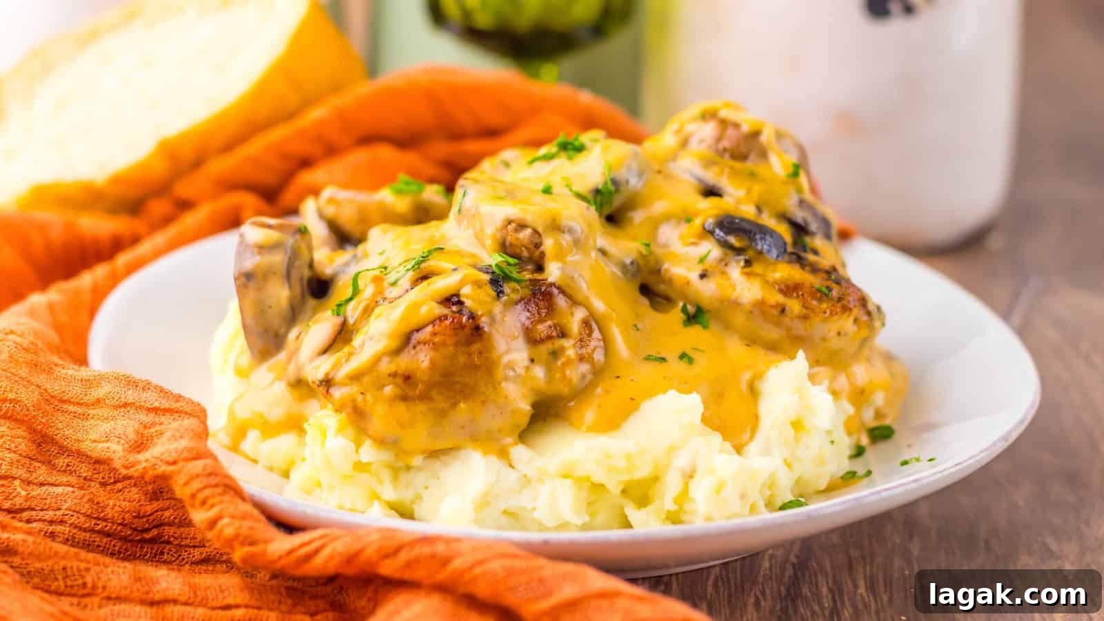 21 Slow Cooker Dinners for Stress-Free Weeknight Meals 15 Plate of mashed potatoes topped with chicken, mushrooms, and creamy gravy, garnished with chopped herbs.