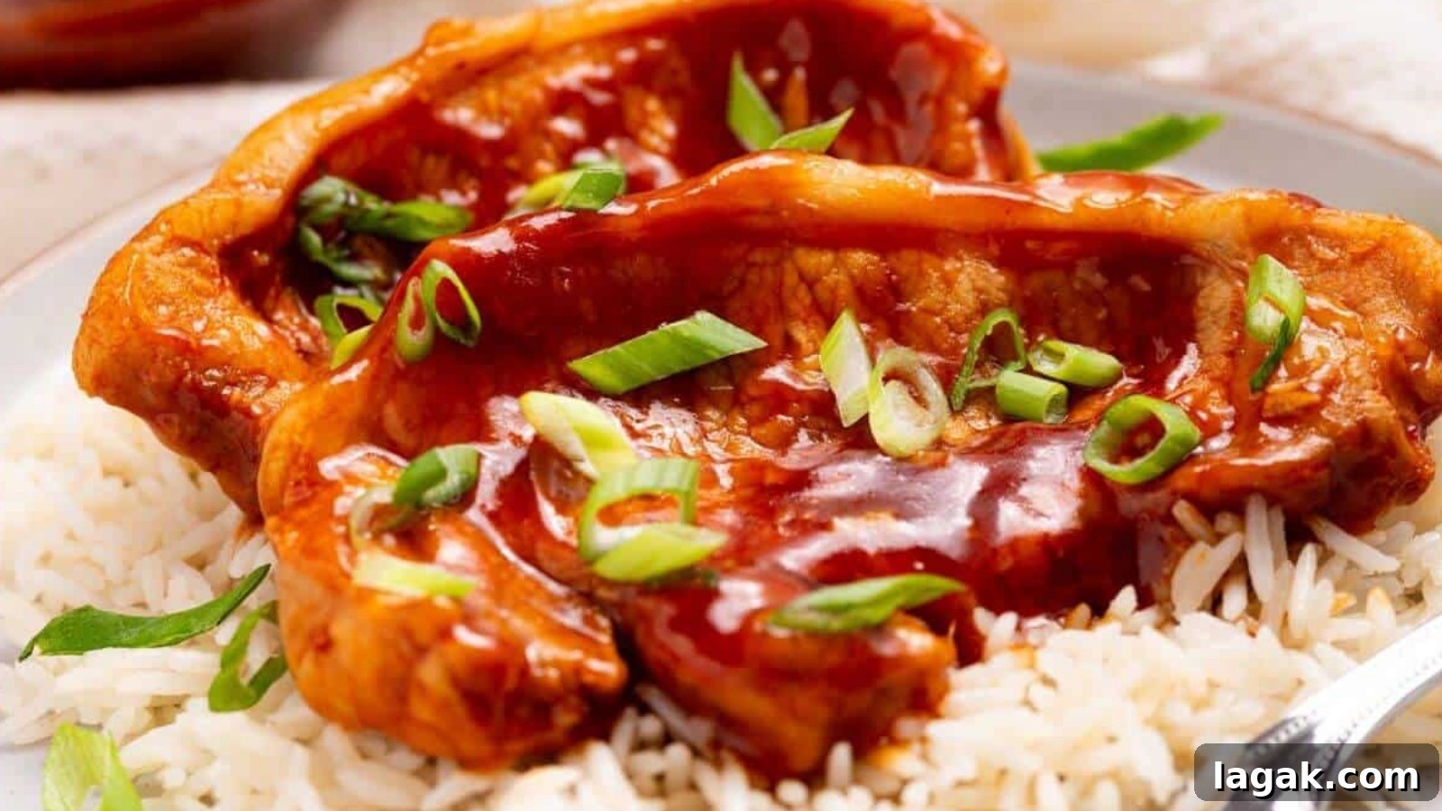 21 Slow Cooker Dinners for Stress-Free Weeknight Meals 6 Slow cooker pork chops with rice and sauce on a plate.