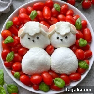 Easter Burrata Caprese Salad with Fresh Herbs and Tomatoes 7 A plate with cherry tomatoes and basil leaves, featuring mozzarella cheese shaped like two sheep faces with black peppercorn eyes, surrounded by more mozzarella as their bodies