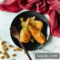 Air Fryer Cinnamon Pears Recipe 10 Air fryer pears sit on a black plate topped with walnuts.