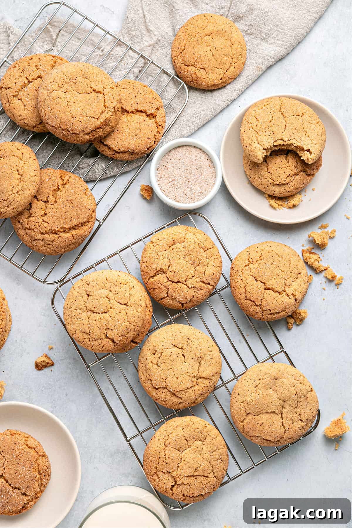 Chewy Browned Butter Snickerdoodle Cookies Recipe 2 Light gray surface with several cinnamon brown butter cookies on wire racks.