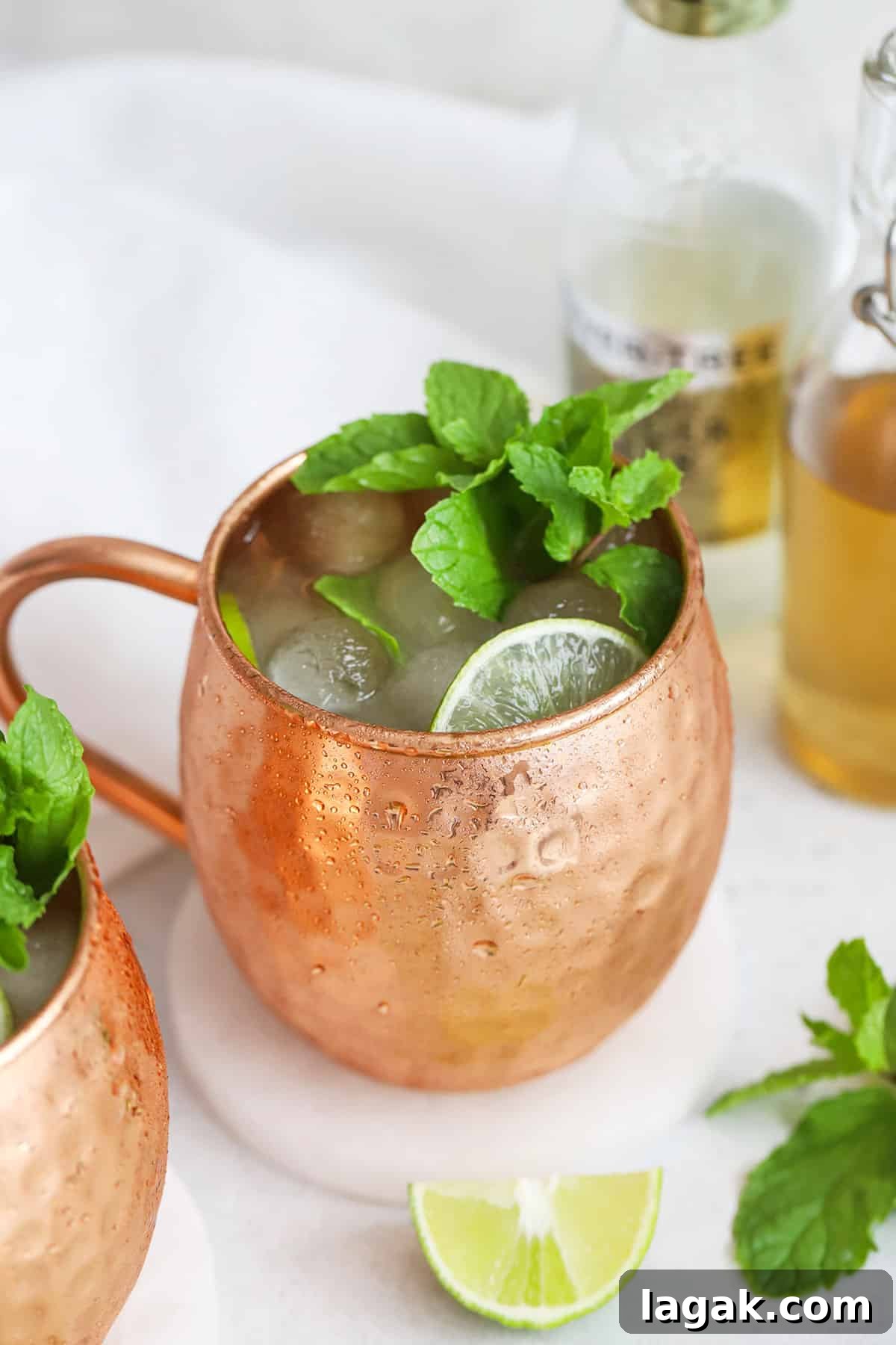 Top Ginger Beers for Crafting Perfect Mocktails 3 Front view of two non-alcoholic moscow mule mocktails in copper mugs with fresh mint and lime slices