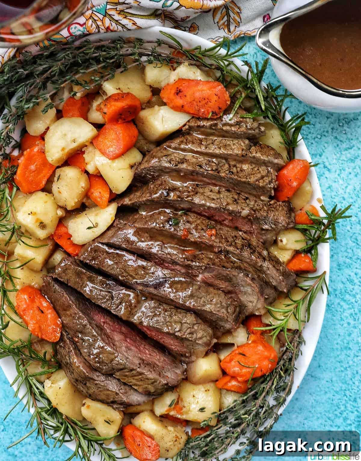 Tender Instant Pot Sirloin Tip Roast Recipe for Juicy Results 2 serving plate with cooked sirloin tip roast surrounded by carrots, potatoes, and herbs with a side of gravy.