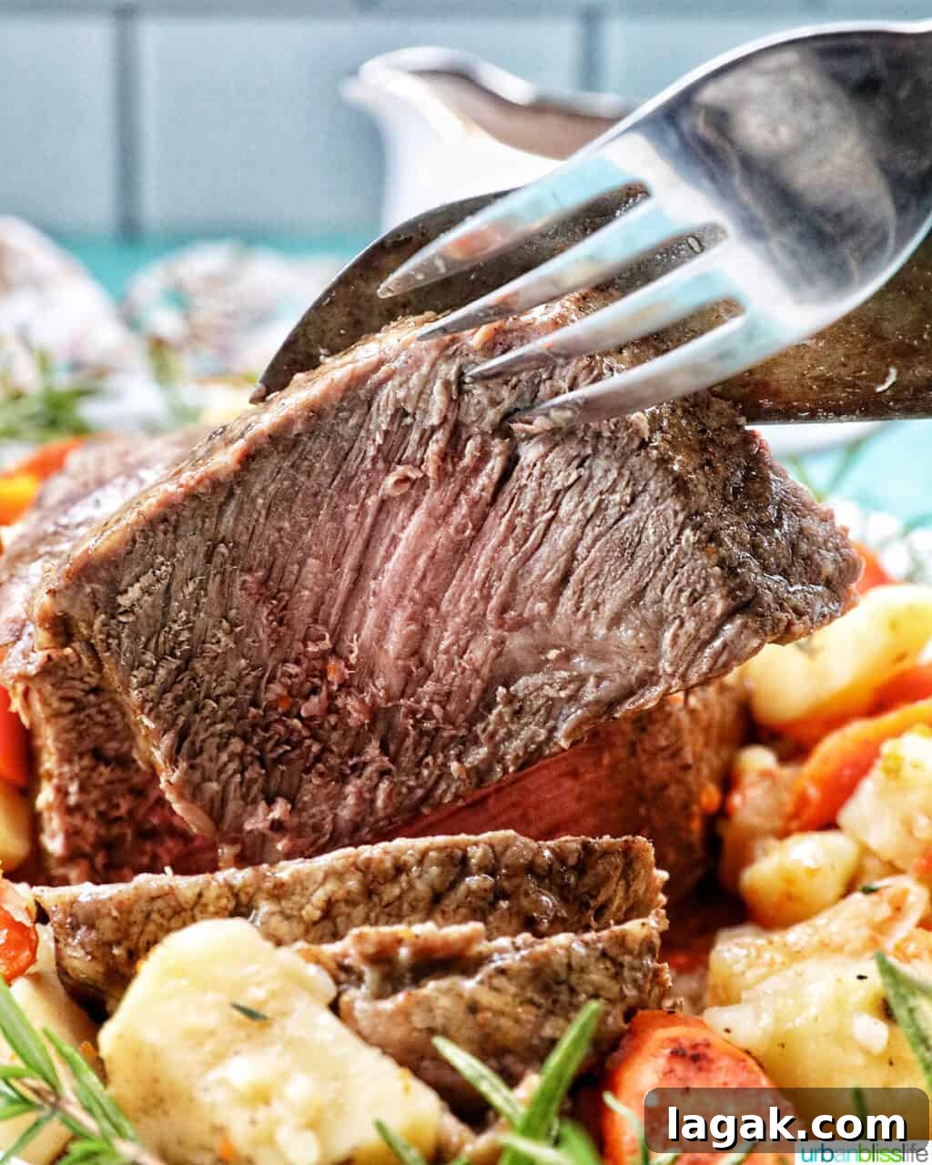 Tender Instant Pot Sirloin Tip Roast Recipe for Juicy Results 12 Large fork and knife holding up a slice of sirloin tip roast with potatoes and carrots in front.