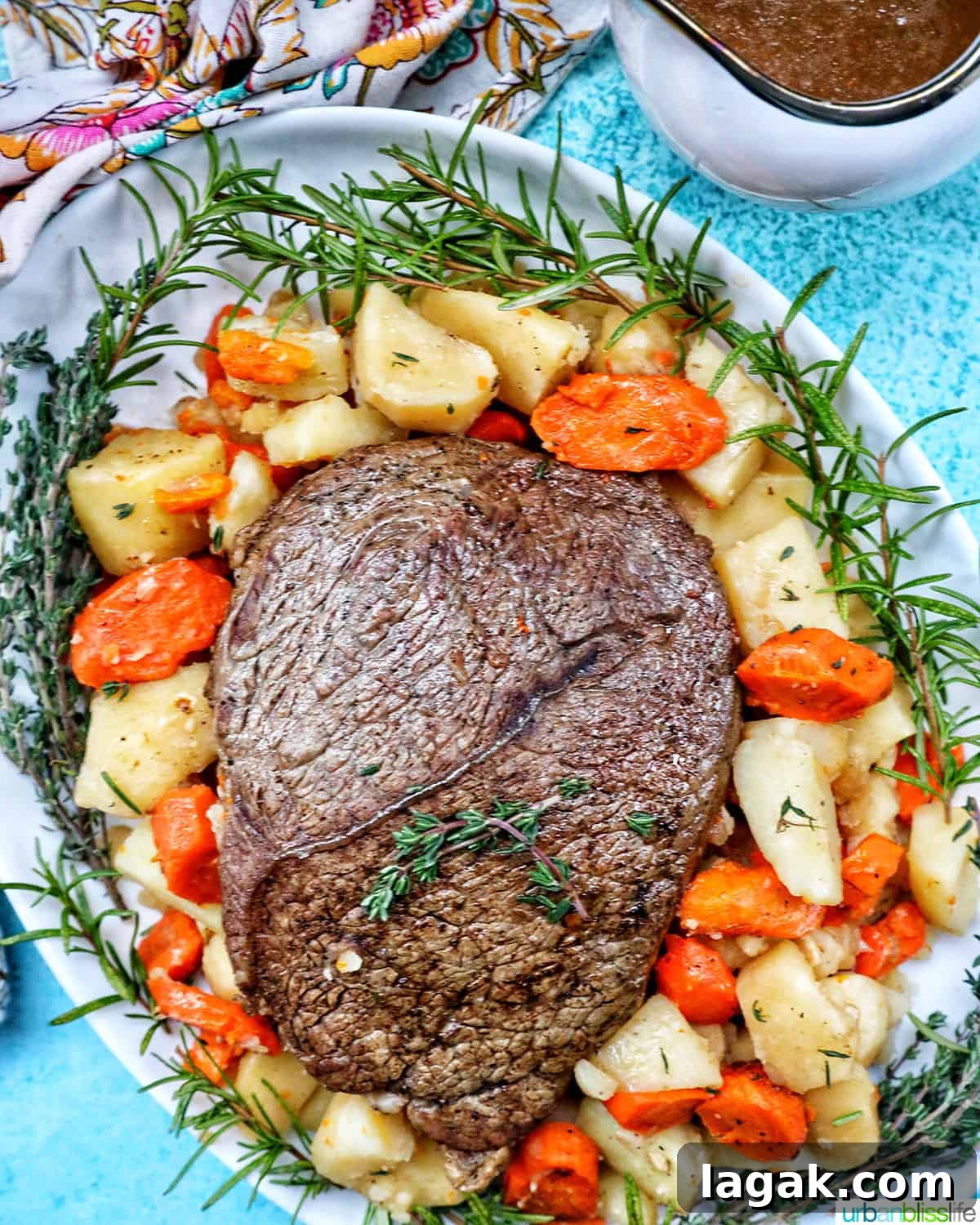 Tender Instant Pot Sirloin Tip Roast Recipe for Juicy Results 3 serving plate with cooked sirloin tip roast surrounded by carrots, potatoes, and herbs with a side of gravy.