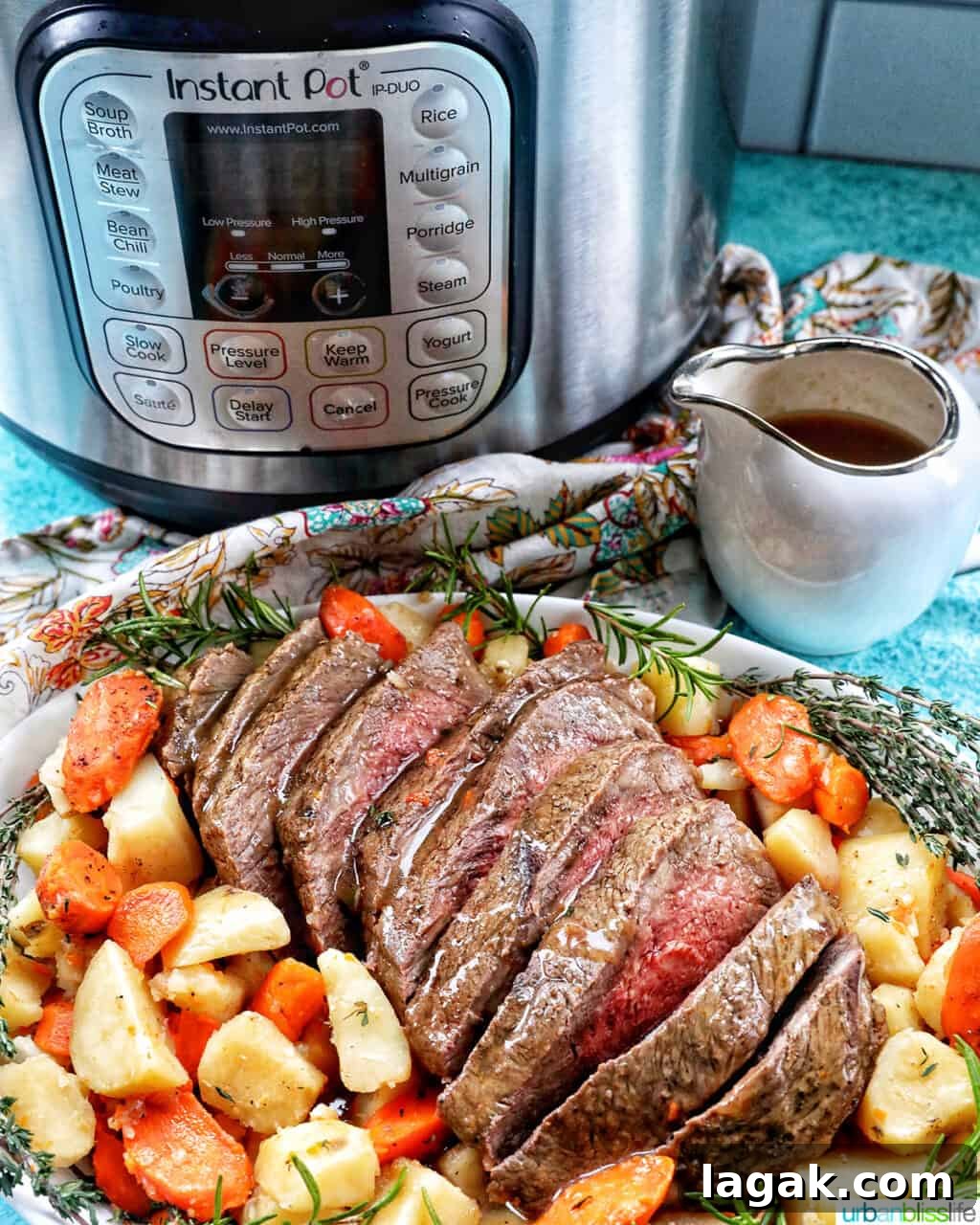 Tender Instant Pot Sirloin Tip Roast Recipe for Juicy Results 14 Sliced sirloin tip roast surrounded by carrots, potatoes, and herbs in front of an Instant Pot with a side of gravy.