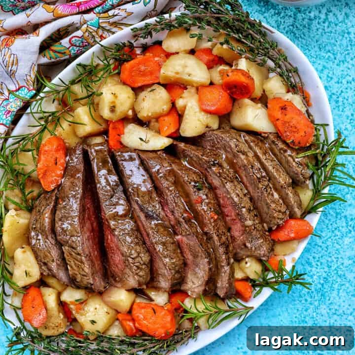 Tender Instant Pot Sirloin Tip Roast Recipe for Juicy Results 19 Sliced sirloin tip roast surrounded by carrots, potatoes, and herbs with a side of gravy.