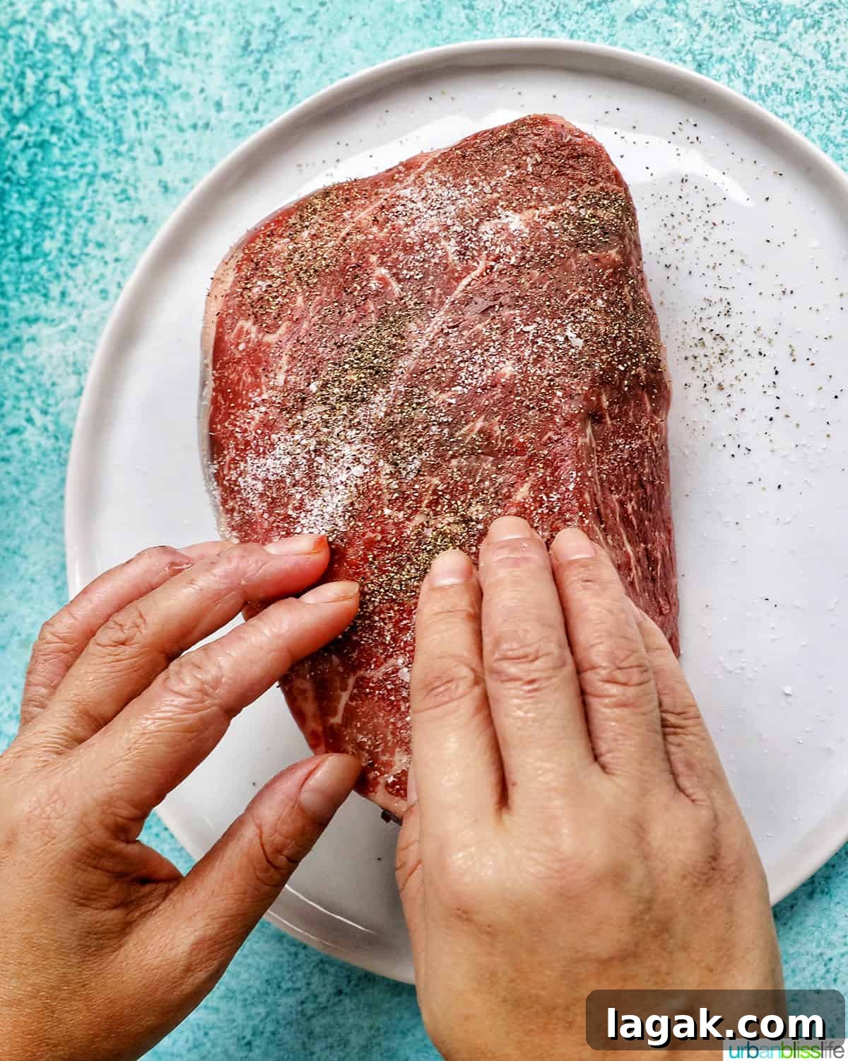 Tender Instant Pot Sirloin Tip Roast Recipe for Juicy Results 5 two hands seasoning sirloin tip roast with salt and pepper on a white plate.