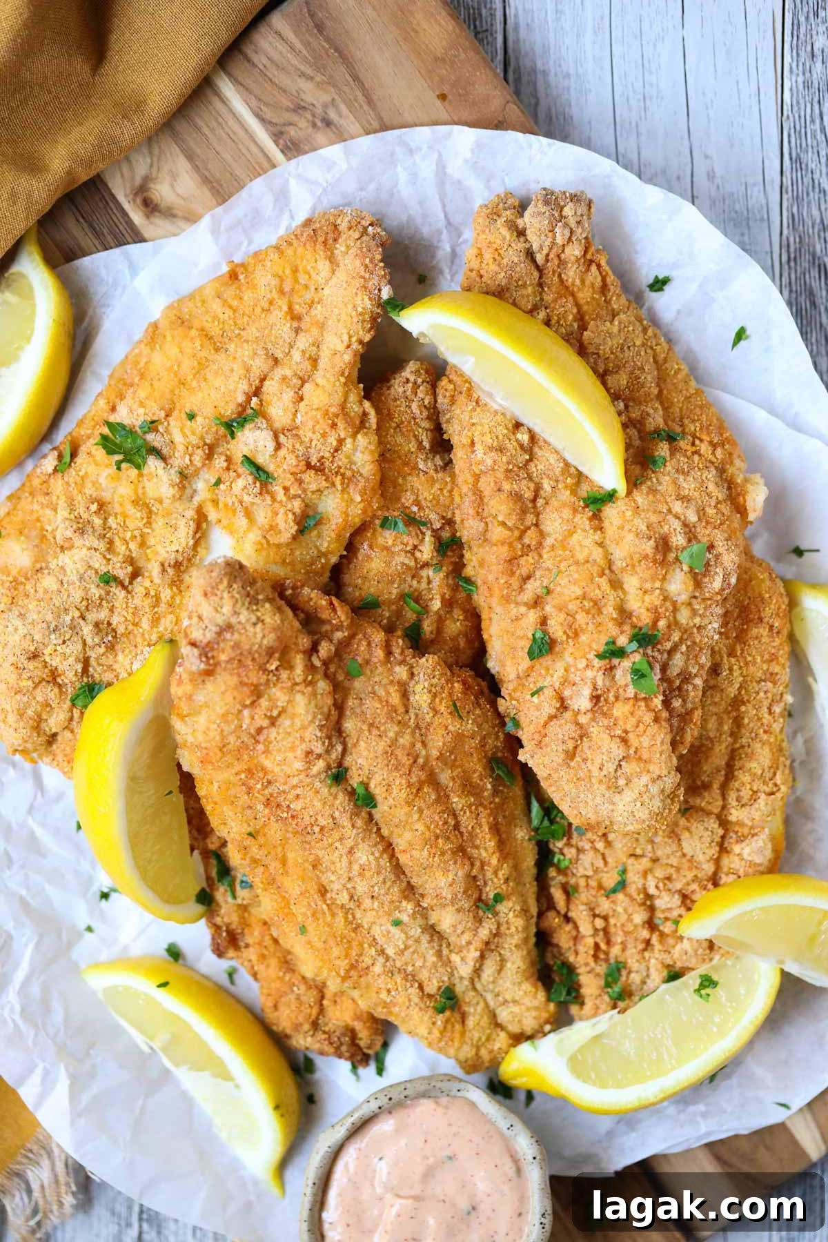 Crispy Oven-Baked Catfish with Garlic and Lemon 8 southern oven fried catfish on a wooden cutting board.