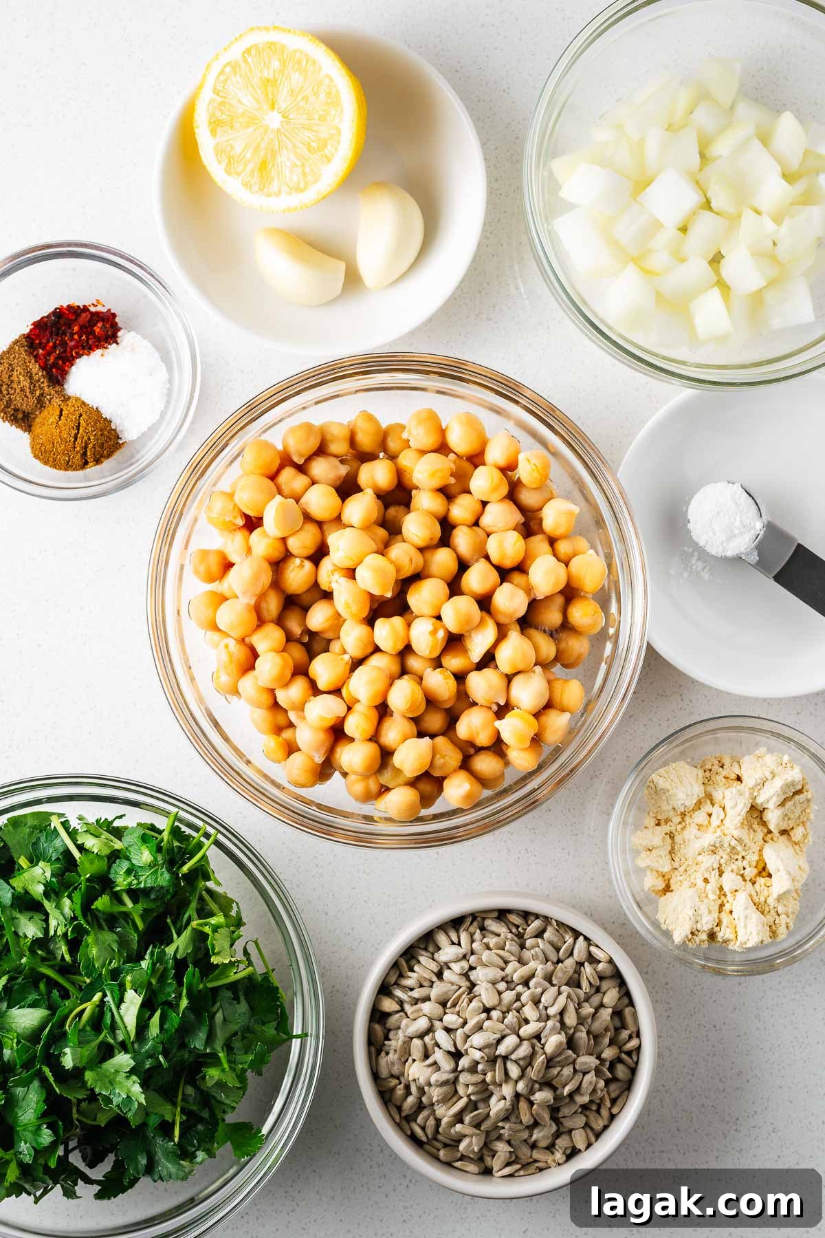 Crispy Baked Falafel Using Canned Chickpeas 4 Ingredients for the baked falafel recipe using canned chickpeas arranged on a white kitchen counter viewed from above.