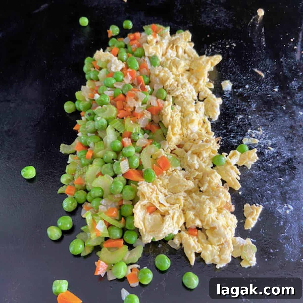 Crispy Blackstone Fried Rice Recipe for Restaurant-Style Flavor 6 Vegetables and eggs cooking on blackstone griddle.
