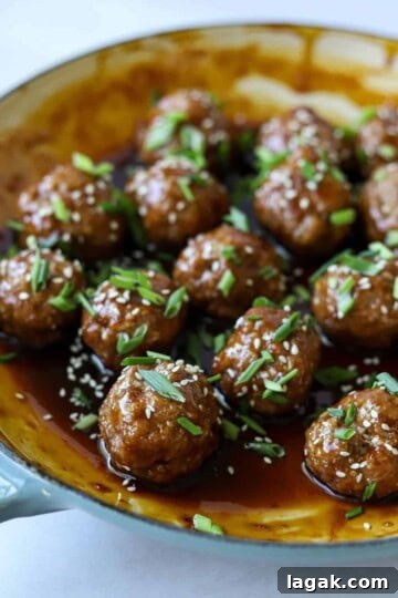Asian meatballs in enamel pan tossed in glaze.