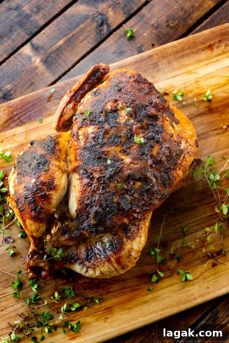 Crispy Air Fryer Whole Chicken Recipe (+ Step-by-Step Video) 2 whole chicken with crispy skin on wooden board with fresh herbs