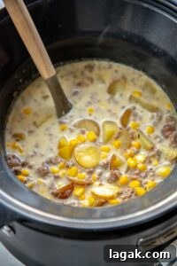 slow cooker with ladle and sausage and potato soup