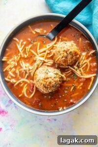 blue bowl filled with spaghetti and meatballs soup