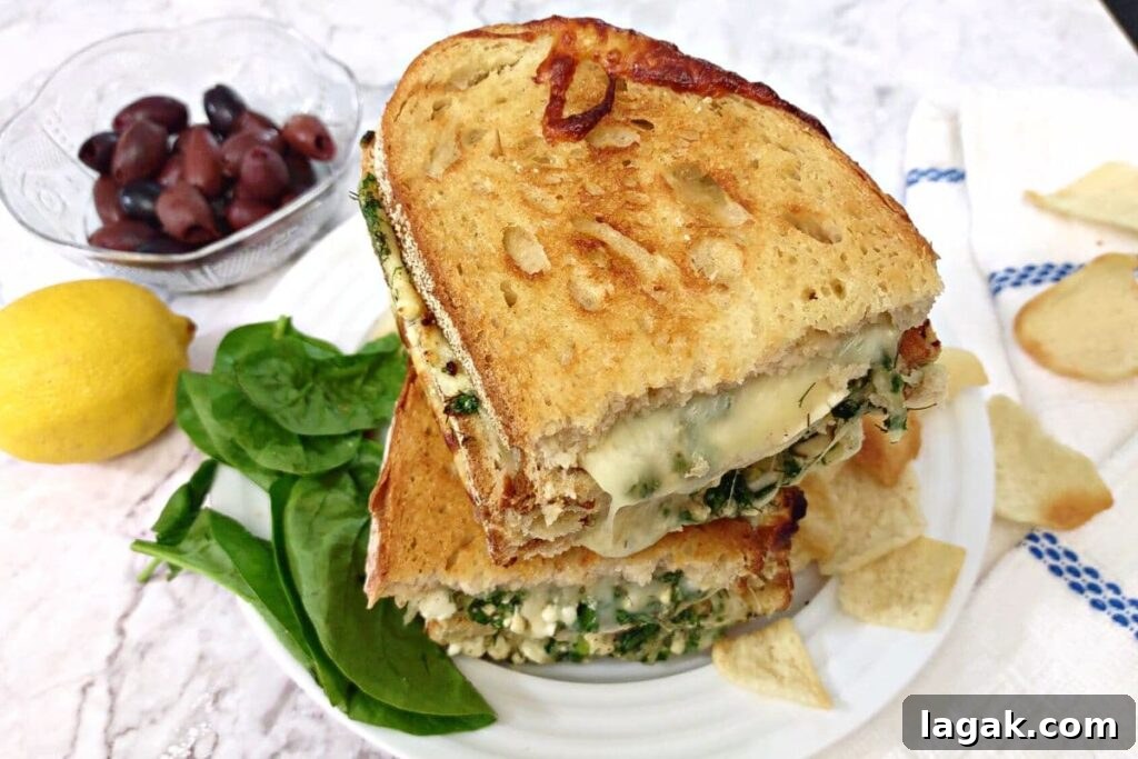 Spanakopita Grilled Cheese Sandwich (Air Fryer Greek-Style) 14 spanakopita grilled cheese halves stacked on top of each other surrounded by veggies