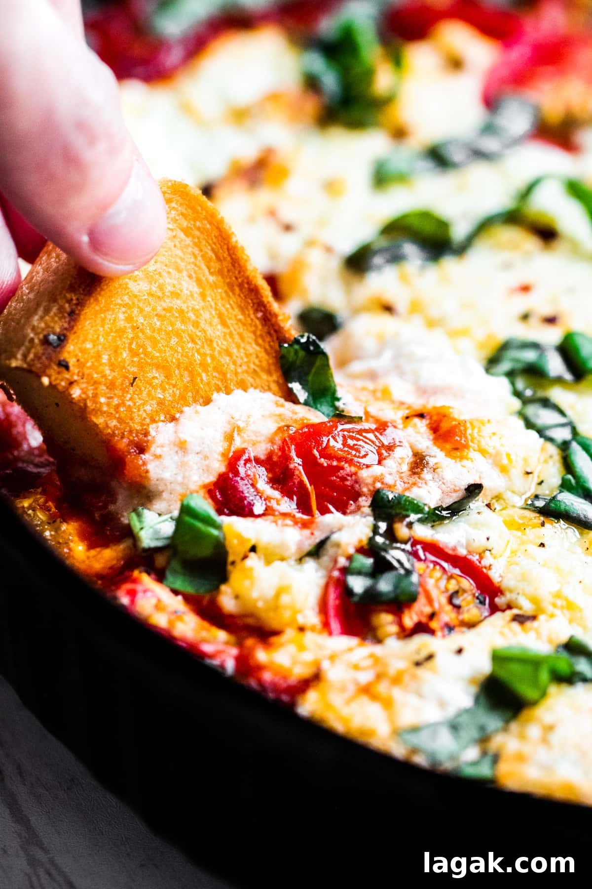 Hand dipping bread into dip.