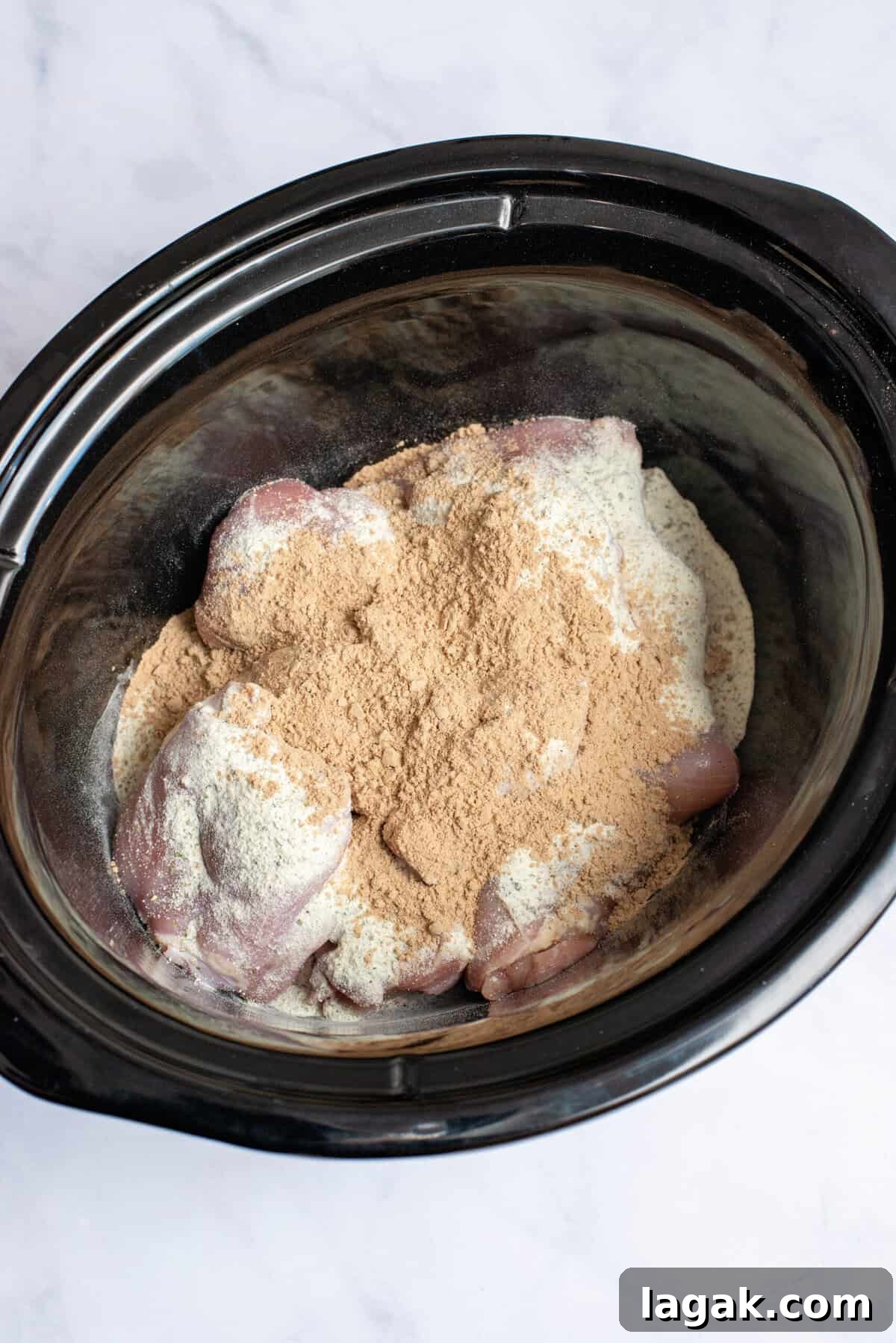 Mississippi Chicken Served Over Creamy Mashed Sweet Potatoes 6 Raw chicken thighs in a slow cooker topped with dry ranch seasoning and au jus gravy mix, ready to be cooked into flavorful Mississippi chicken.