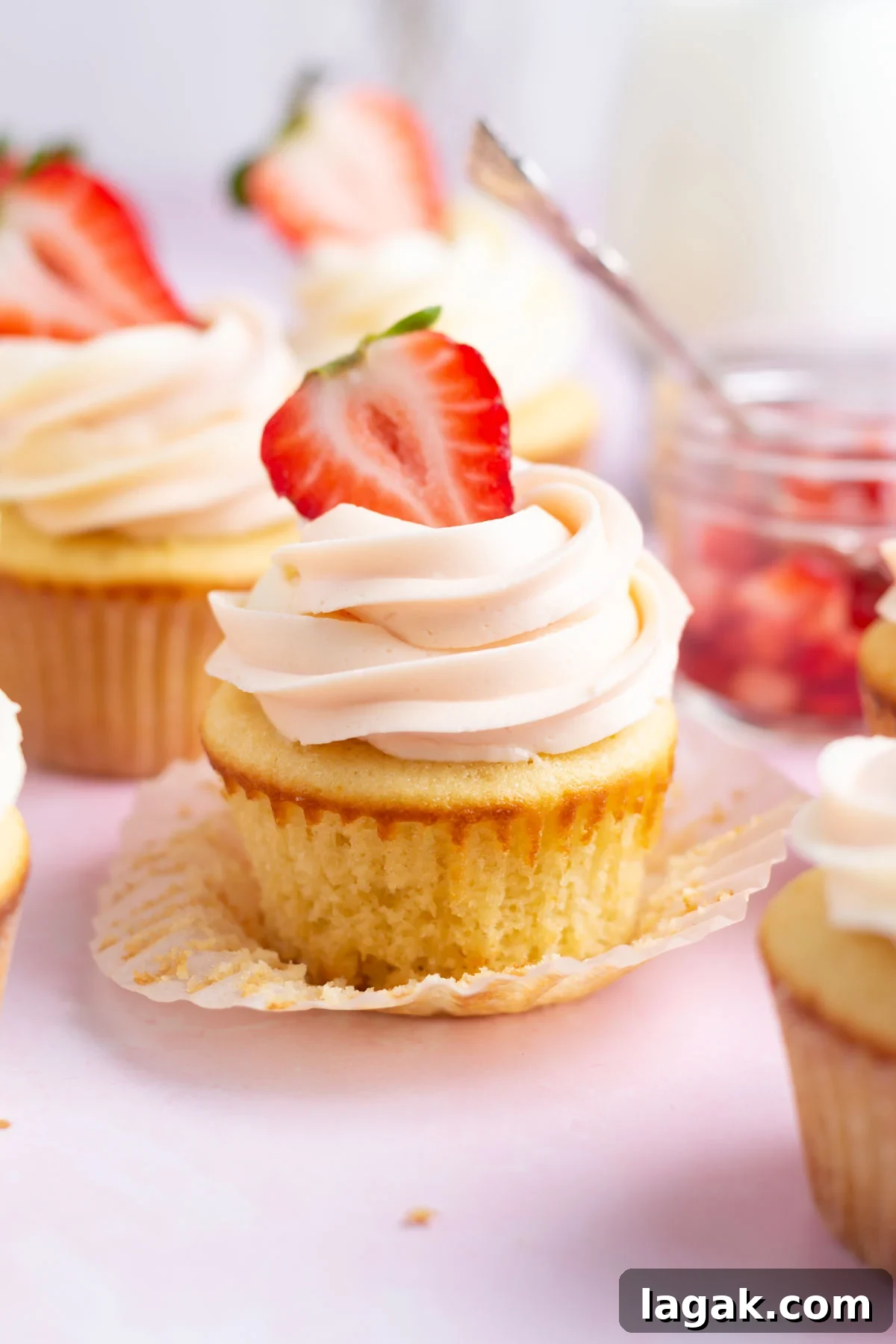 Strawberry filled cupcakes; one with the liner pulled off to show texture.