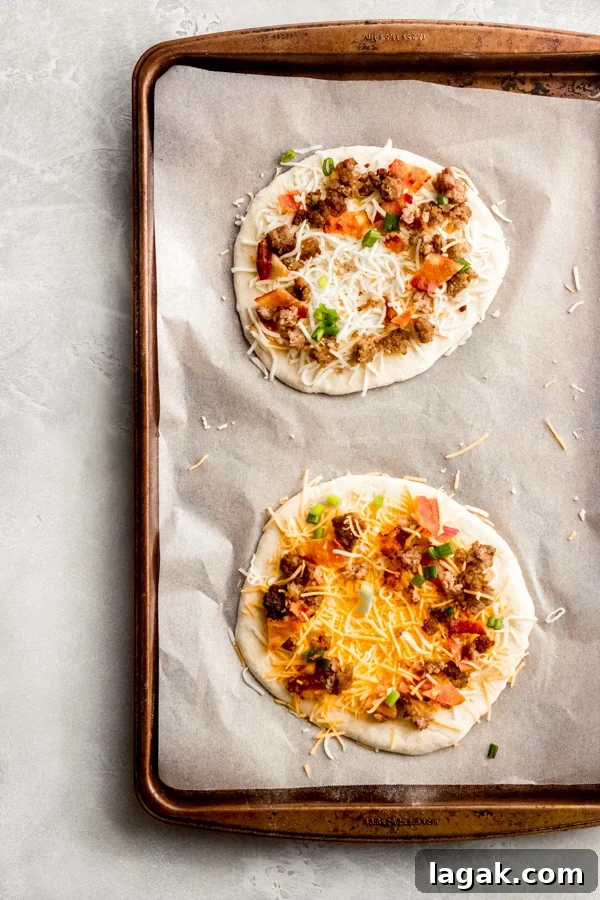 Breakfast pizzas assembled on a baking tray. Breakfast pizzas assembled on a baking tray.