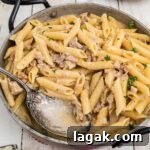 A close up picture of a one pot turkey pasta in a skillet with a spoon.