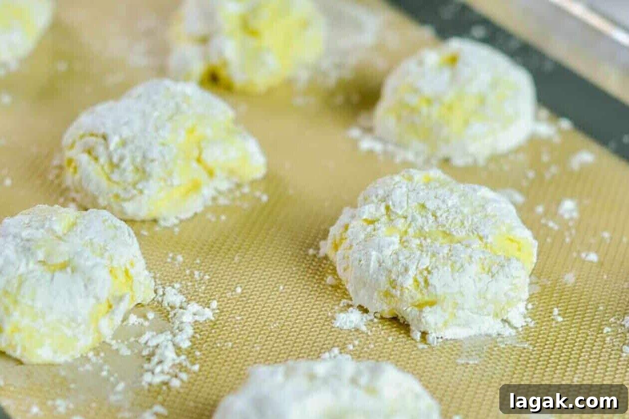 Cake Mix Cookies with Cool Whip: Soft, Fluffy No-Fuss Recipe 6 unbaked lemon cool whip cookies on a baking sheet.
