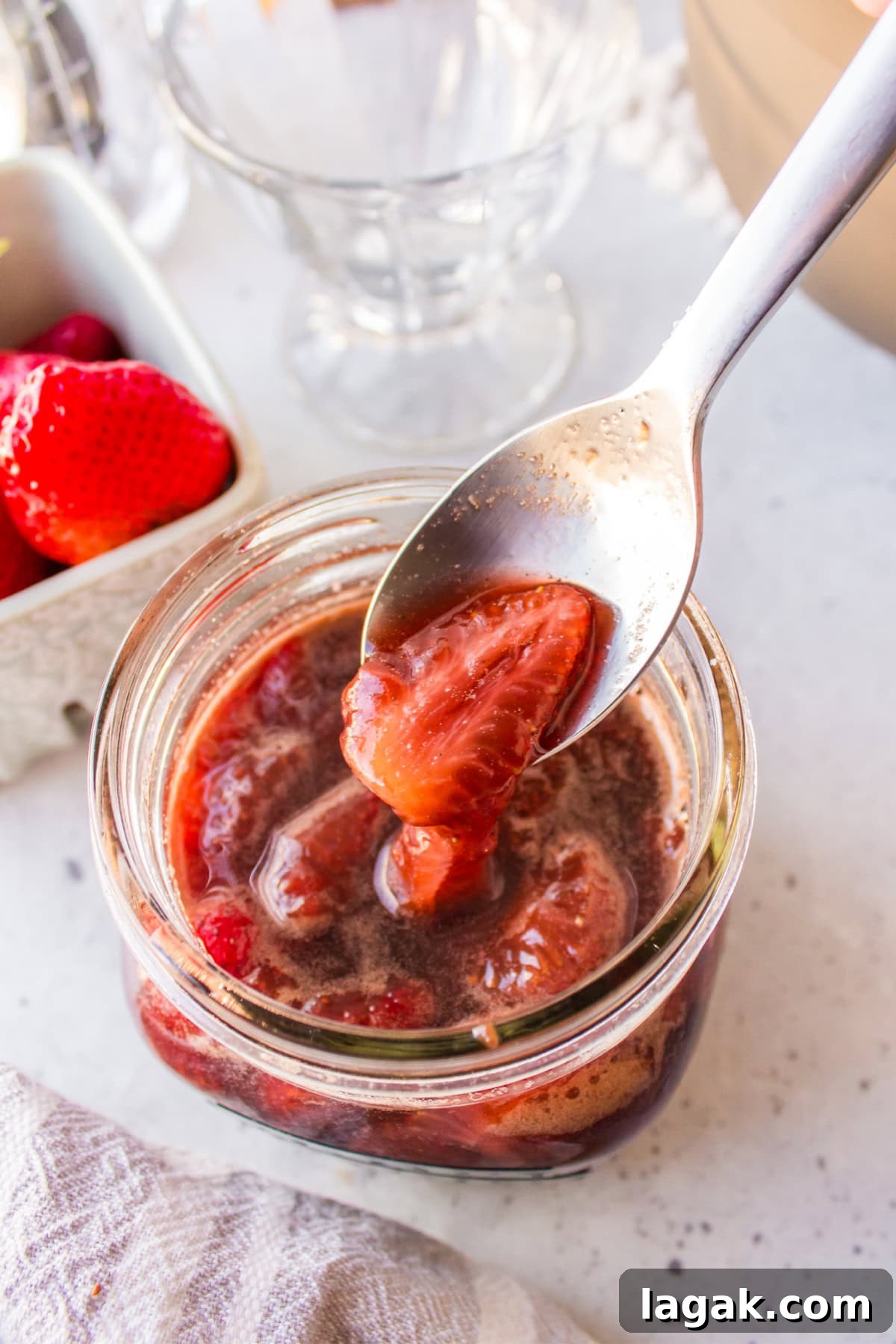 spooning balsamic strawberry sauce out of jar