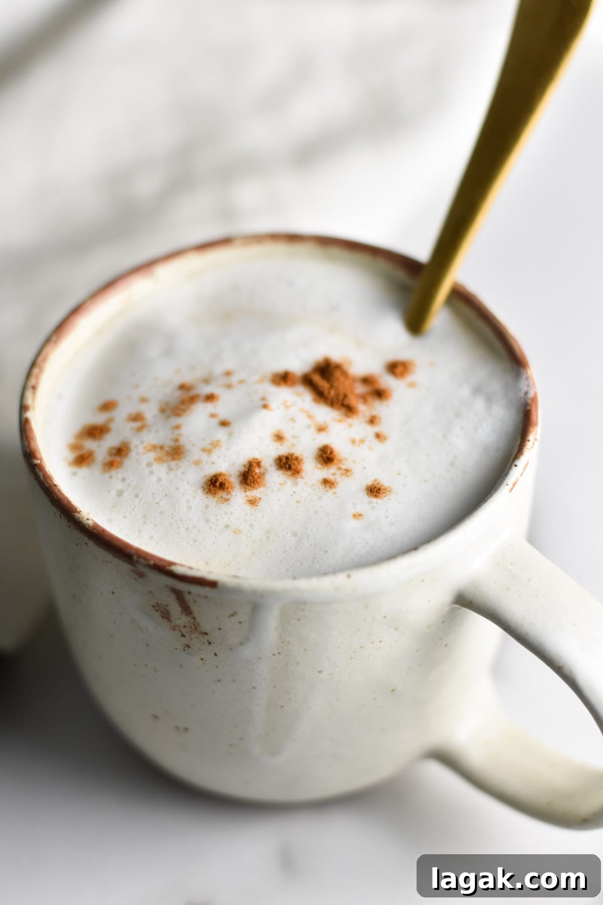 A spoon dipping into a tea latte.