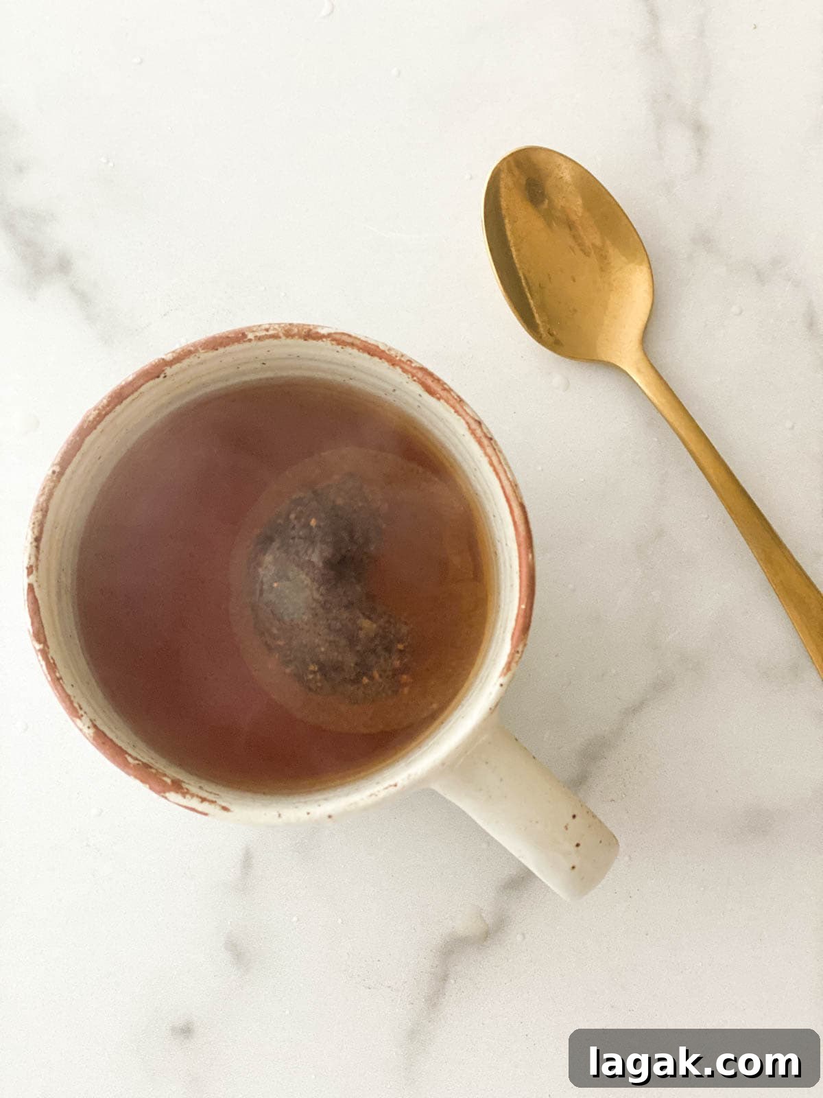 A tea bag steeping in a mug.