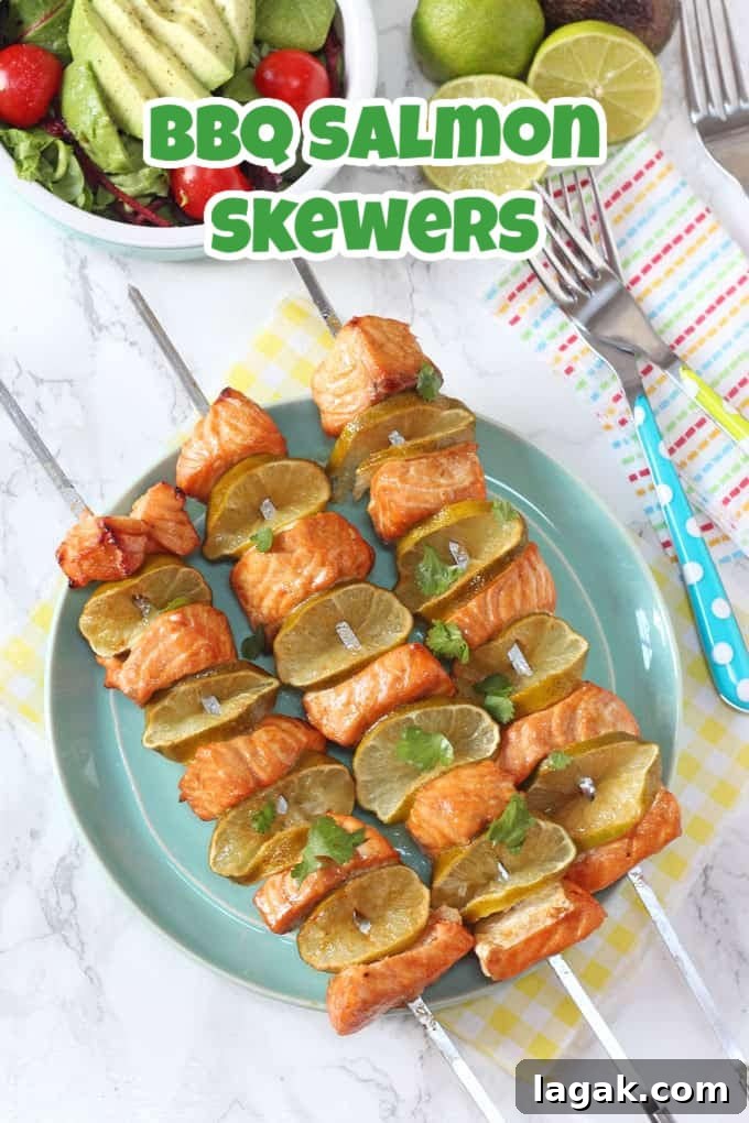 3 BBQ Salmon Skewers on large stainless steel skewers on a light blue plate with side salads in the background.