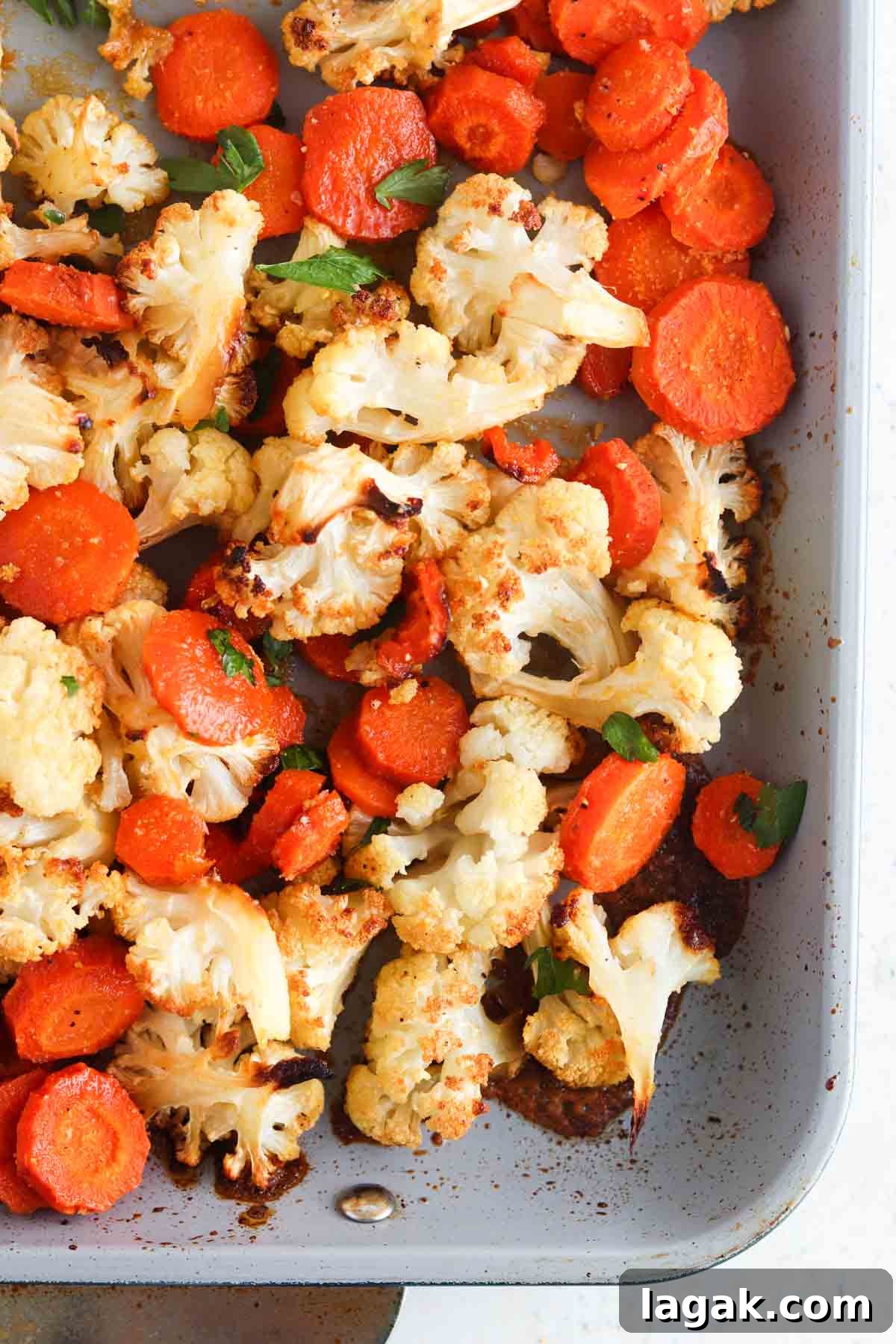 Roasted cauliflower and carrots on a sheet pan.
