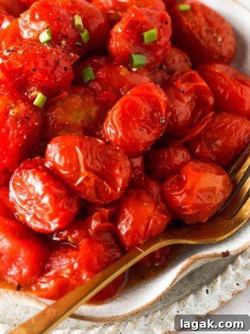 close up photo of tomatoes in the air fryer with seasoning on top