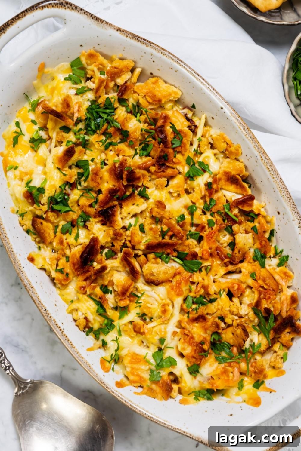 A casserole dish with baked Crack Chicken garnished with parsley in it.
