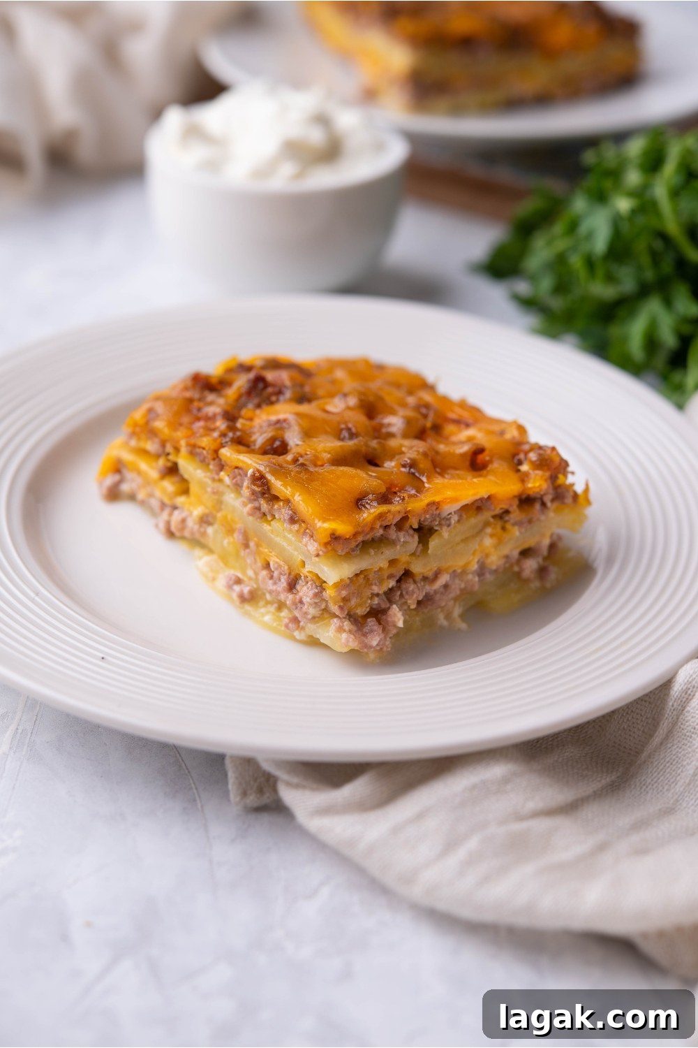 Single serving of hamburger potato casserole on a white plate.