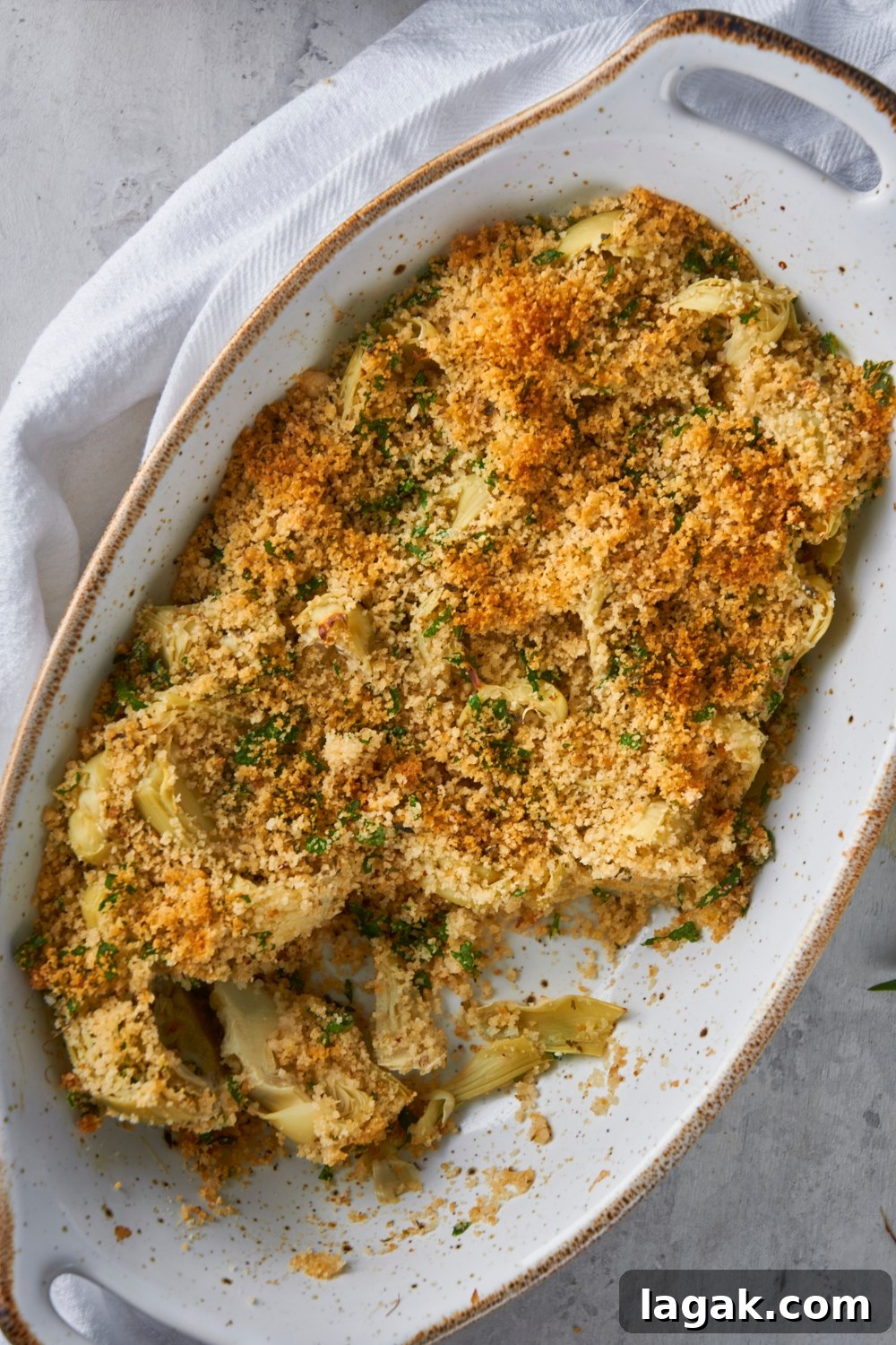 A casserole dish with baked artichoke casserole.