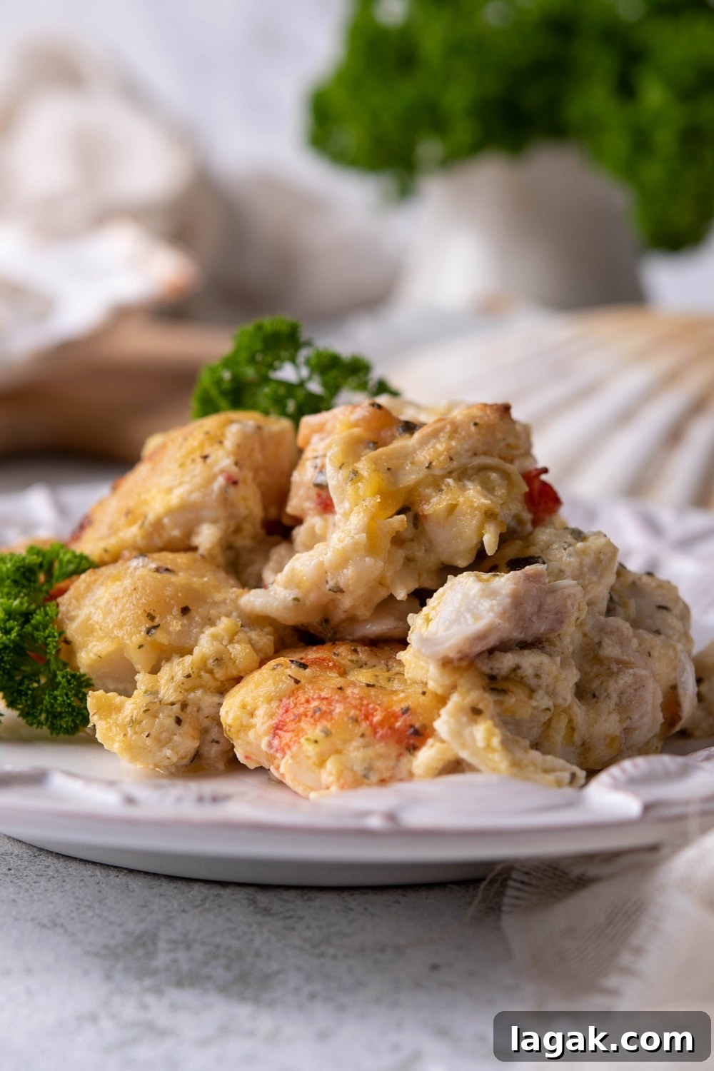 Scallops, crab meat, and shrimp covered in a creamy sauce on a plate.