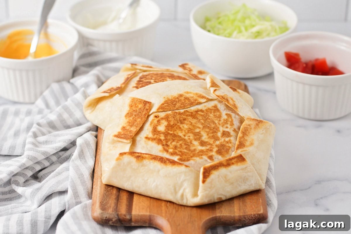Two crunchwrap supremes on a cutting board.