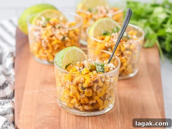 Esquites recipe served in cups with cilantro, Cotija and more on top.