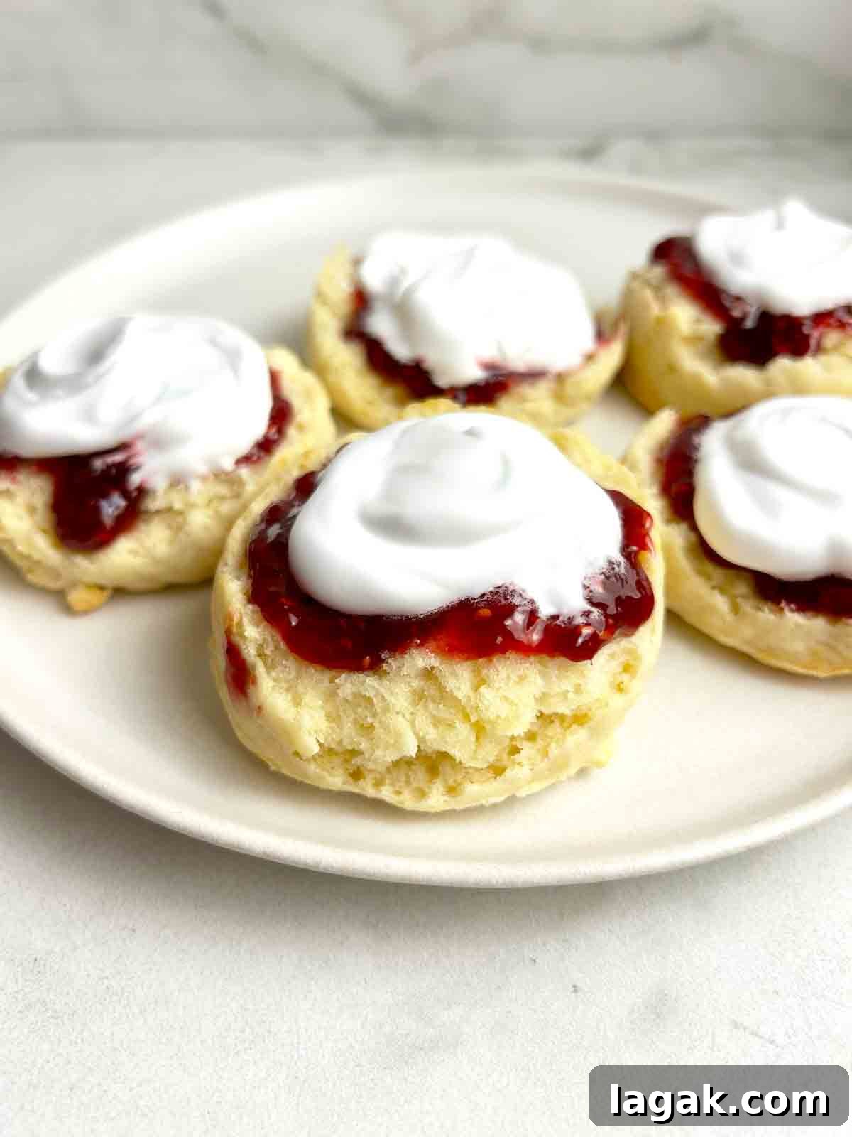 scones cut in half and topped wth jam and cream.