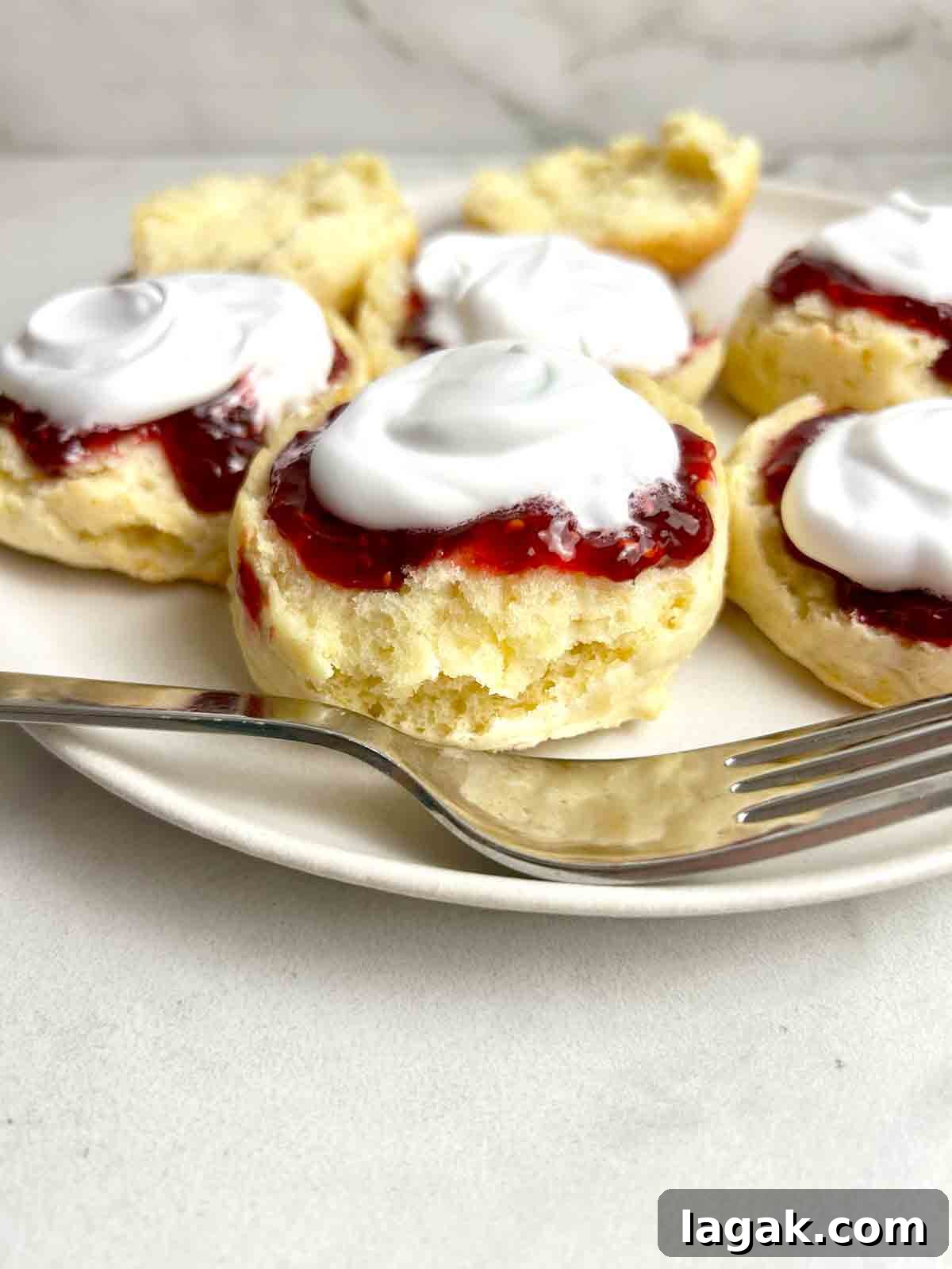scones cut in half and topped wth jam and cream.