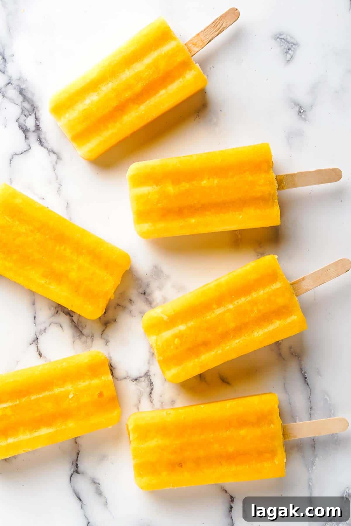 mango popsicles on marble background