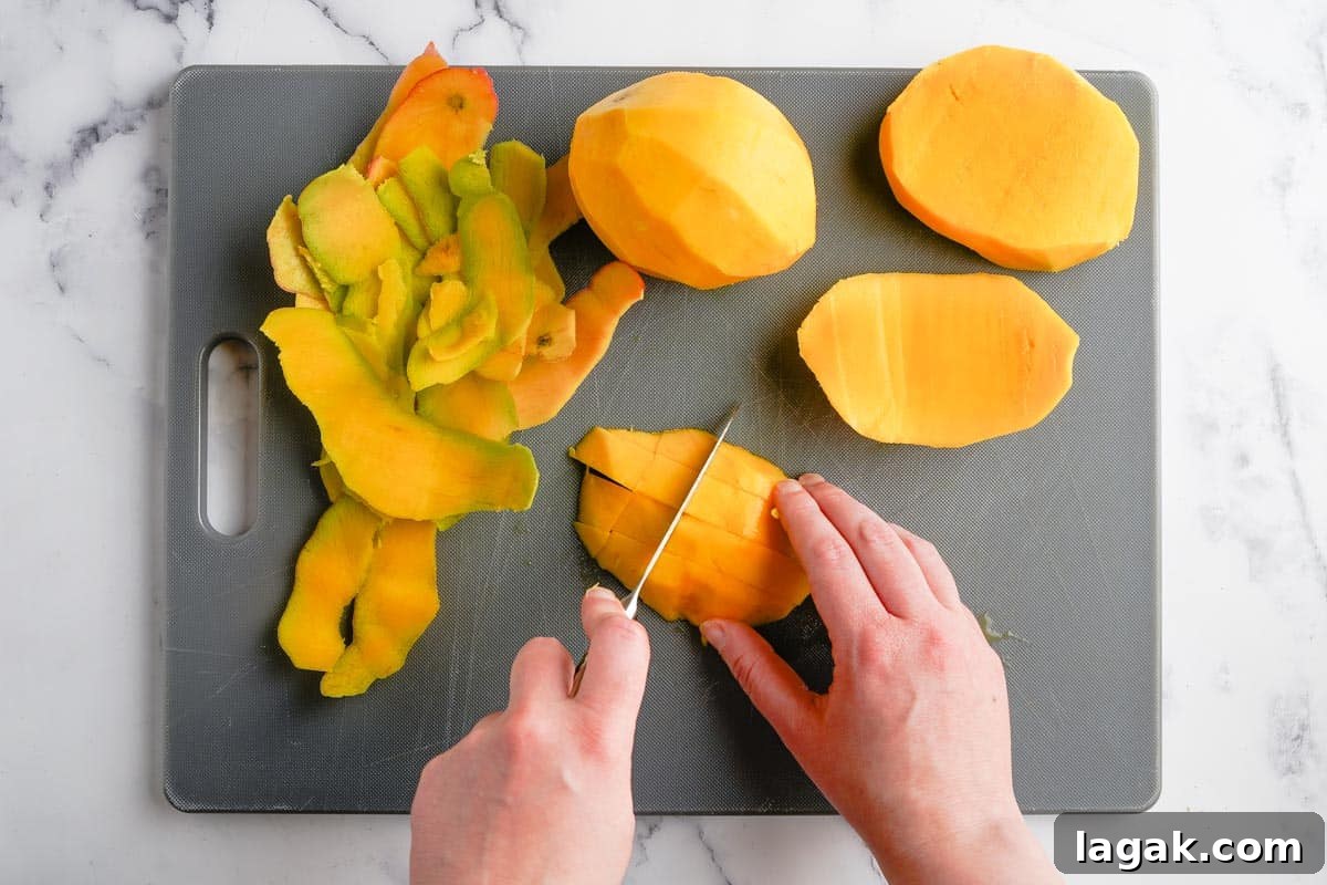 mango being cut into chunks on grey cutting board