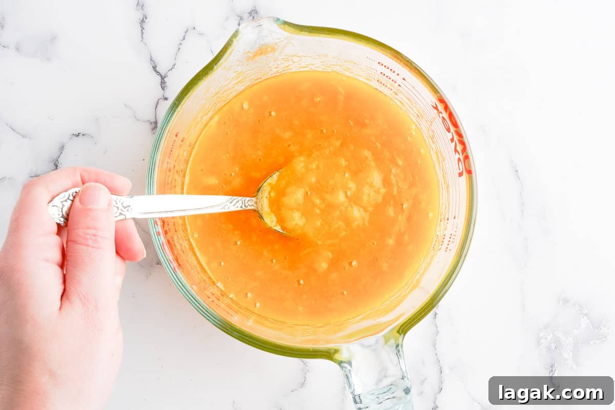 spoon scooping popsicle mix out of glass measuring cup