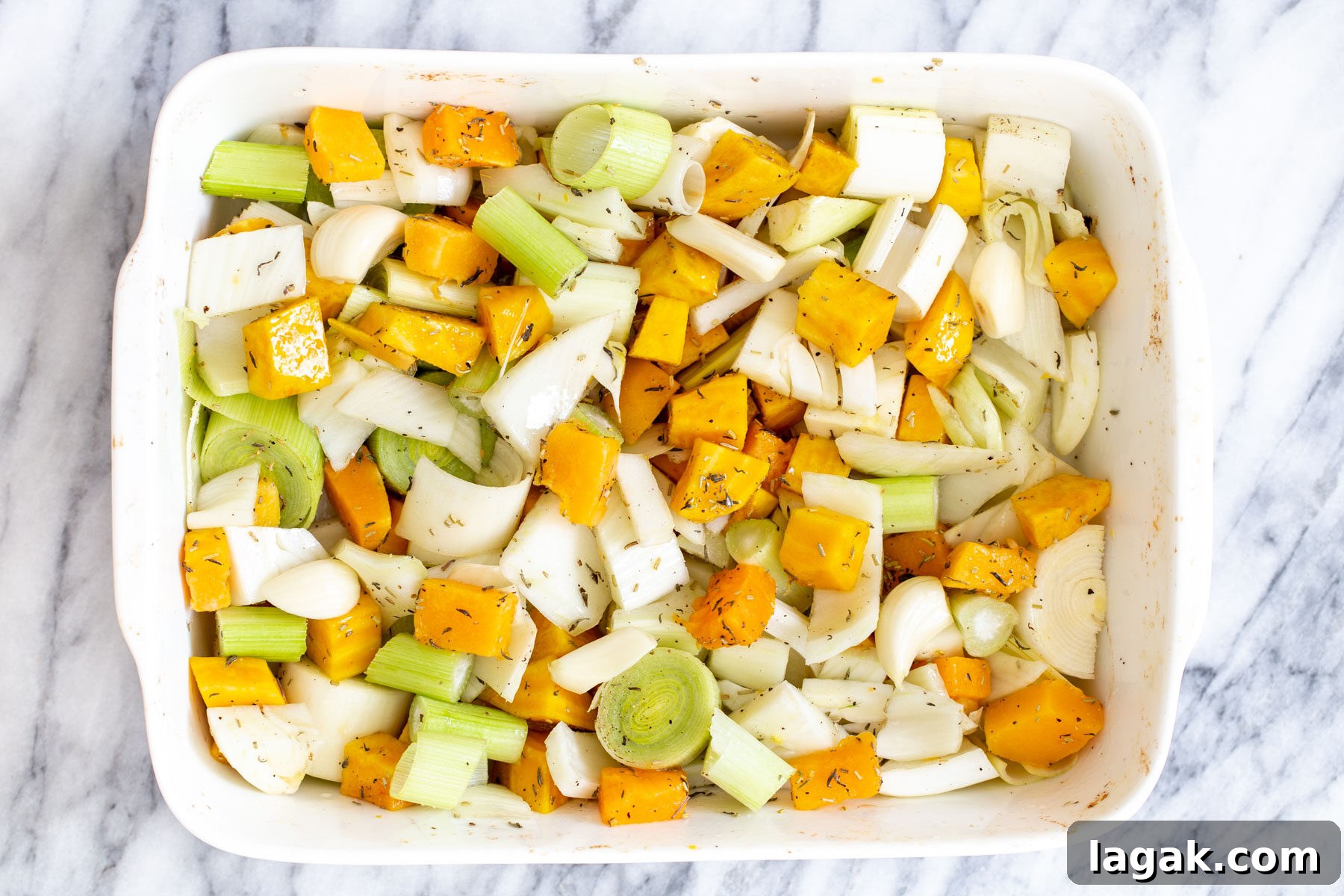roasted root vegetables tossed with seasoning in a casserole dish
