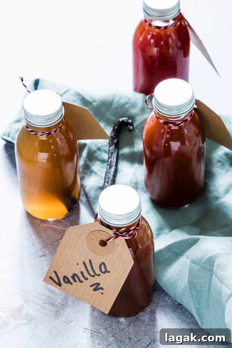 The completed Instant Pot Vanilla Extract poured into individual bottles and tied with a handwritten gift tag sitting on a blue cloth dish towel