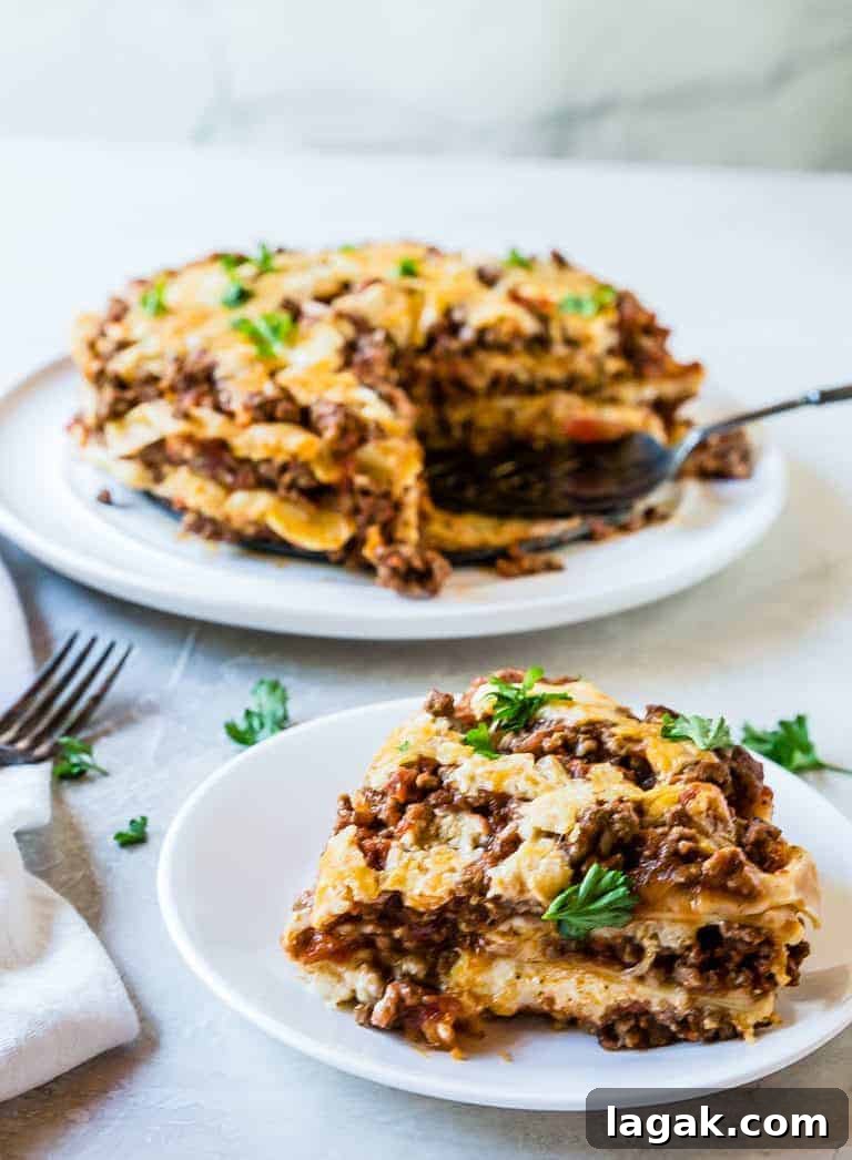 one serving of Instant Pot Lasagna cut from the whole dish and served on a white plate with a parsley garnish