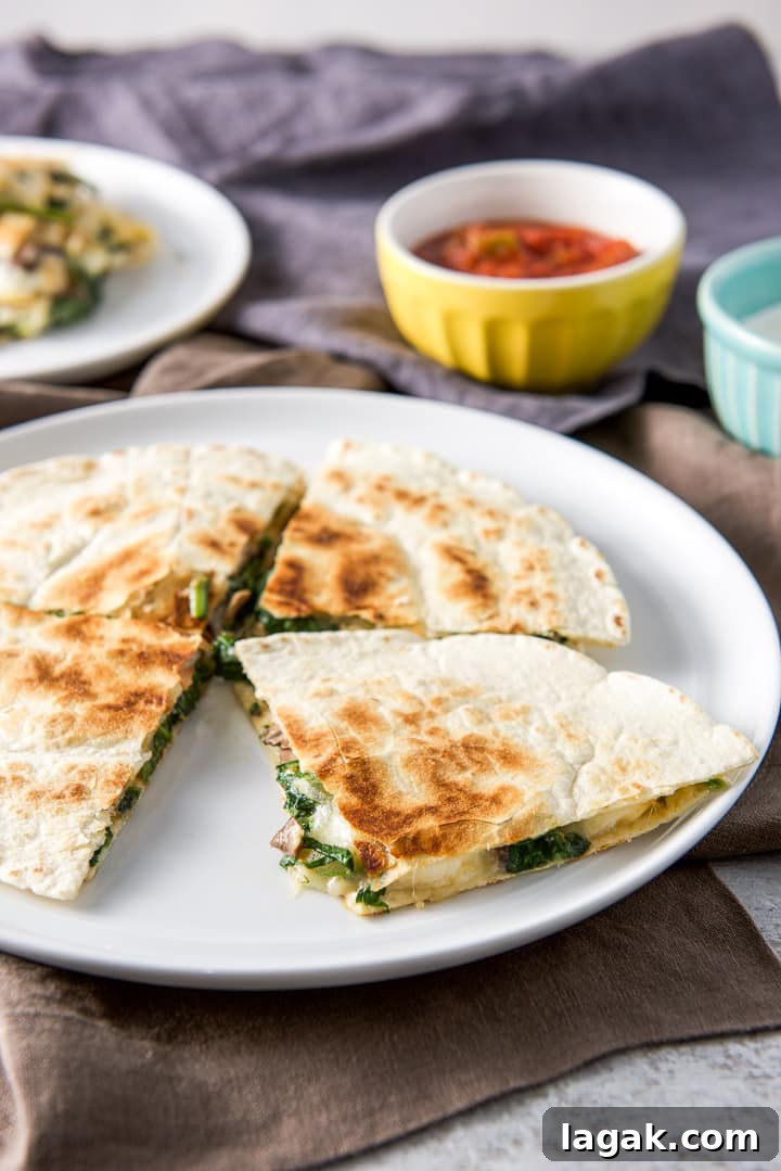 Closer view of the quartered mushroom and spinach quesadilla on the plate