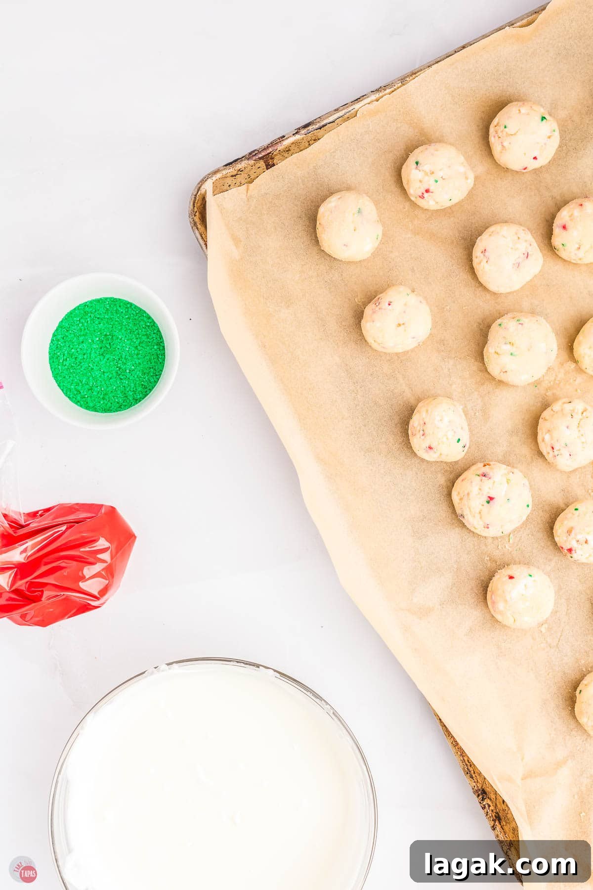 scoops of cake batter on a baking sheet with parchment paper