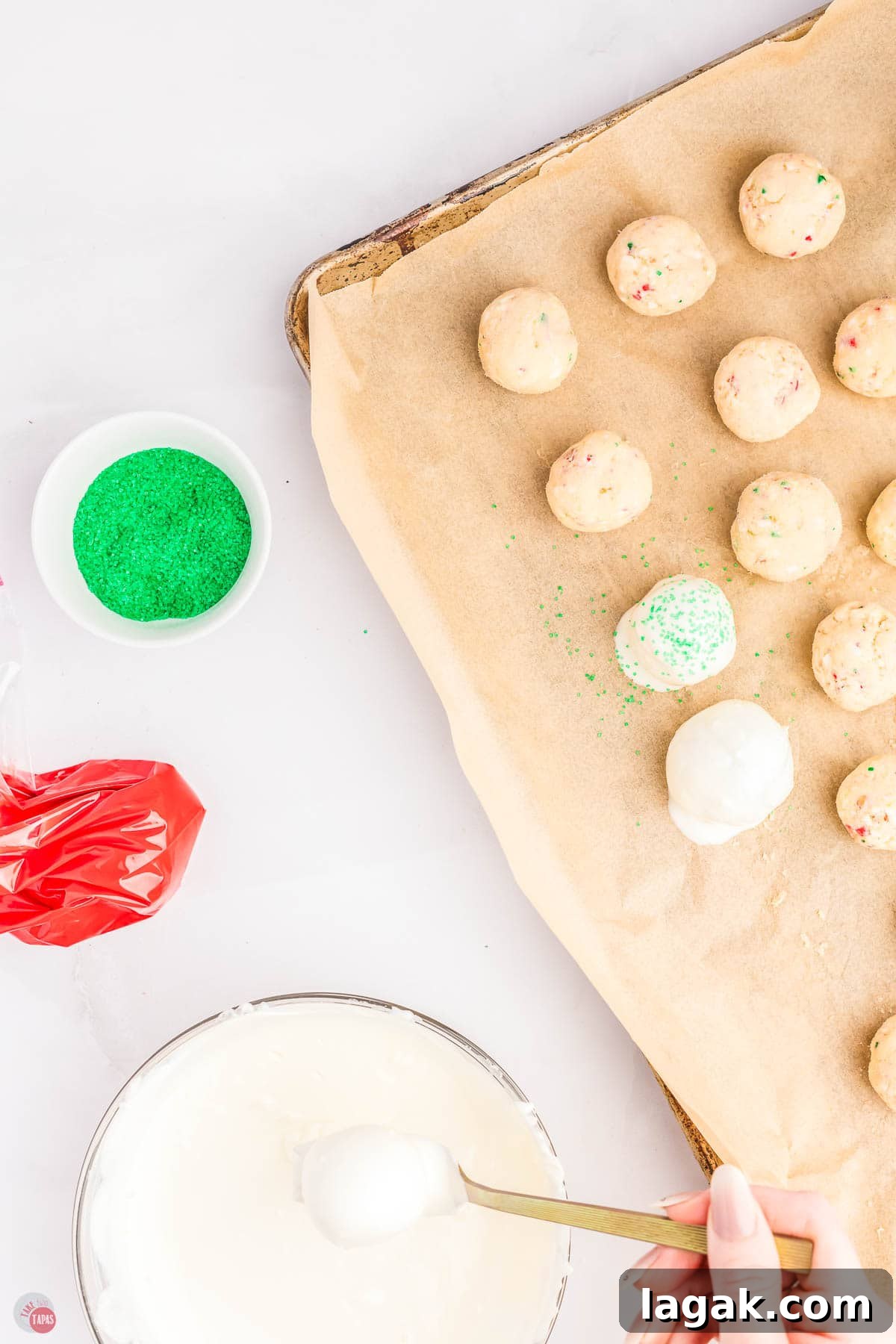 cake balls being dipped in white chocolate on a baking sheet
